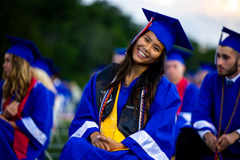 Students in blue robes graduate